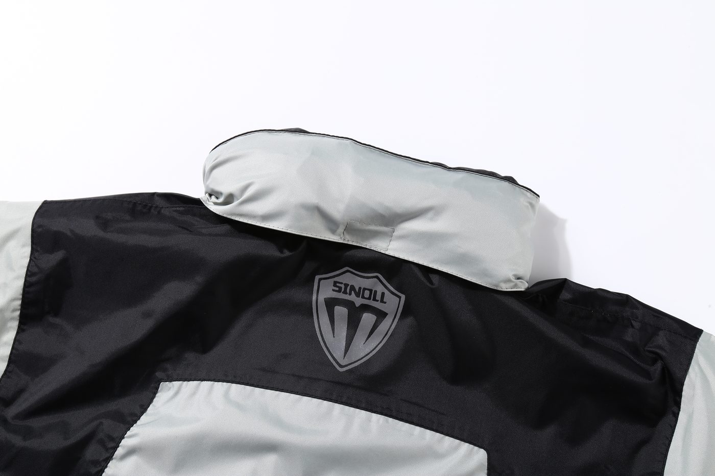 MOTOSINOLL shield badge on the upper back with reflective elements — the shield reads clearly in headlights.