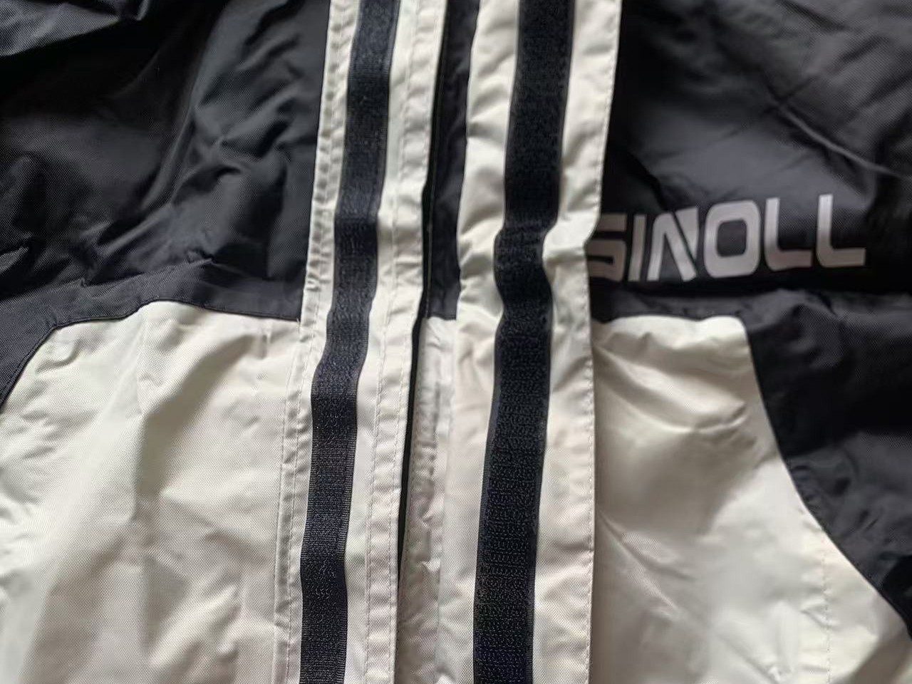 Imperial Grey front closure — zip tape and hook-and-loop storm flap below the MOTOSINOLL chest print