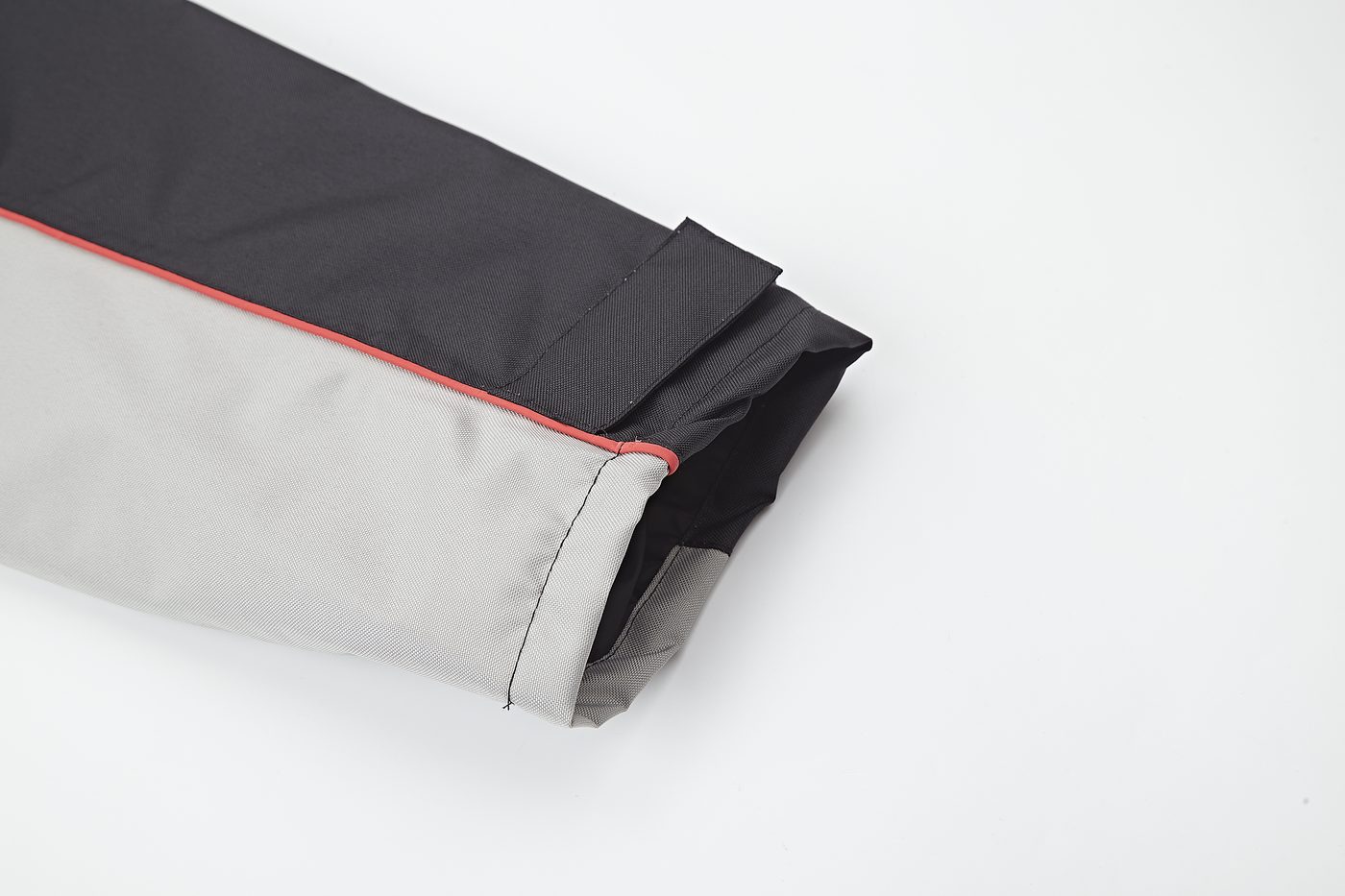 Hem facing with orange-red piping on the grey colorway